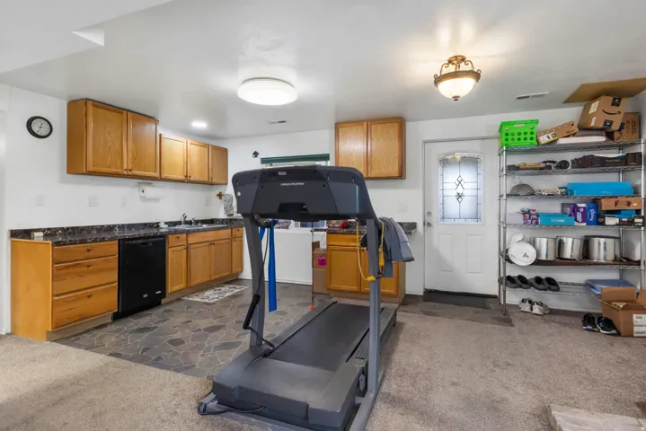Exercise area with dark stone finish flooring and dark colored carpet