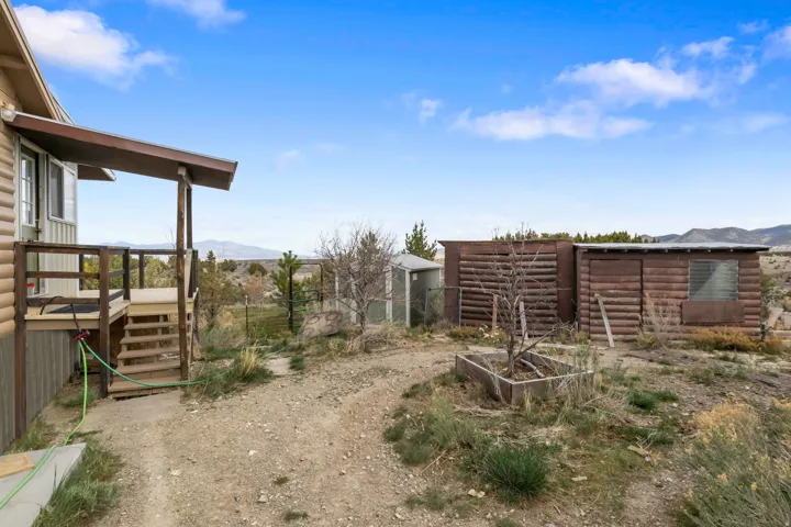 View of yard featuring a vegetable garden and a deck with mountain view