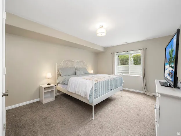 Bedroom featuring light colored carpet and baseboards