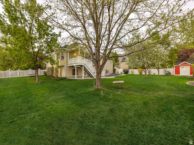 Fenced backyard with a patio, a storage shed, and a wooden deck