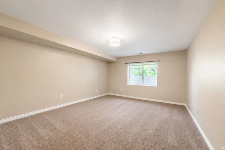 Spacious room featuring neutral carpeting and light-toned walls
