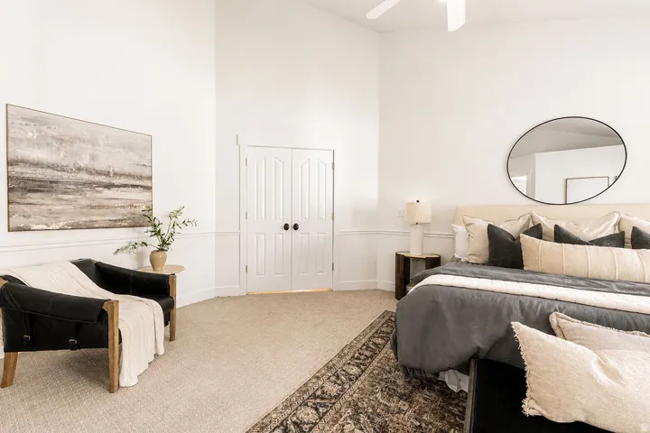 Spacious room featuring vaulted ceilings, neutral-toned carpeting, and a ceiling fan
