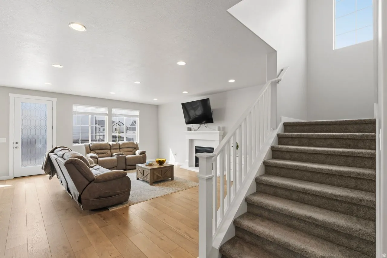 Living room featuring light wood finished floors, a fireplace, and recessed lighting