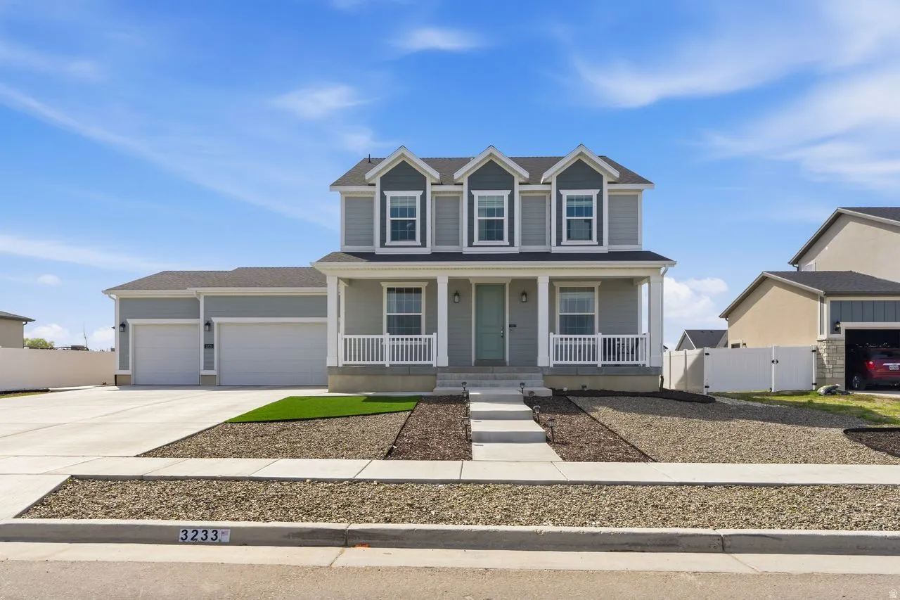 View of front of house with a gate, covered porch, an attached garage, and concrete driveway