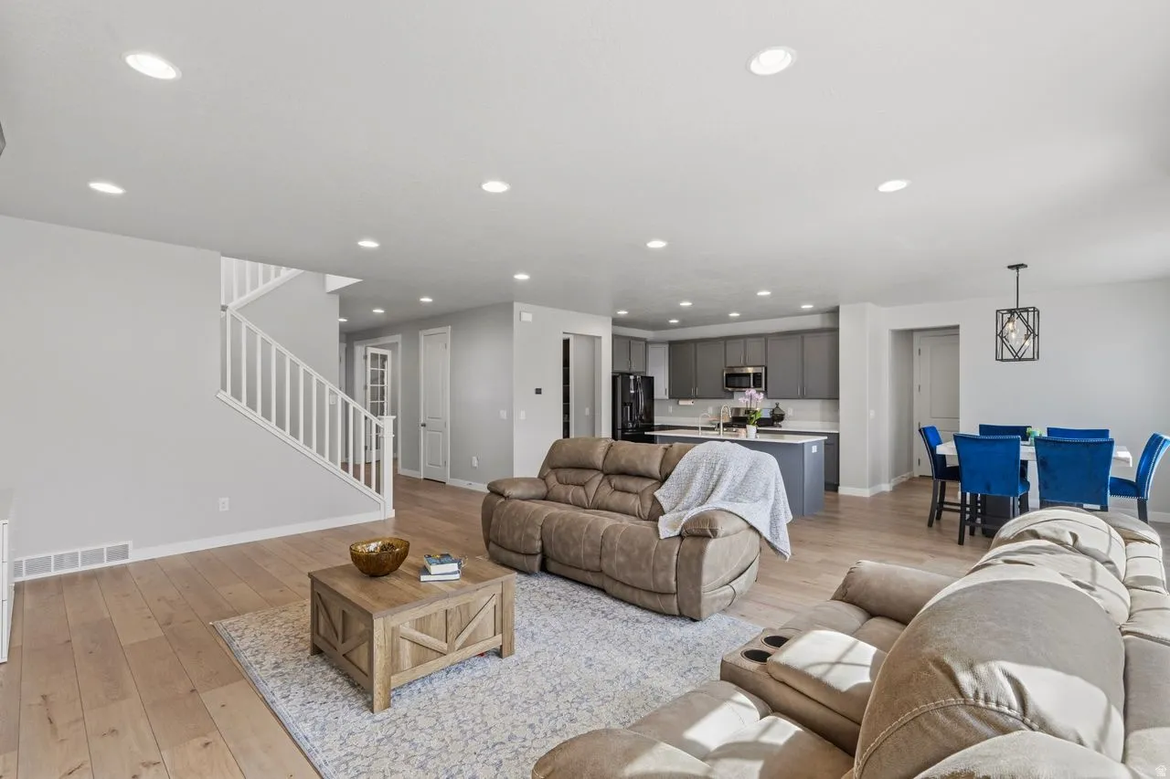 Living area with light wood finished floors and recessed lighting
