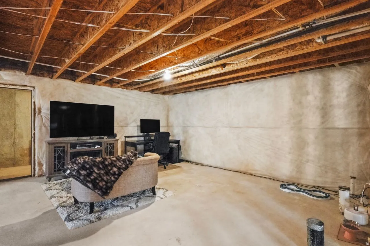 Unfinished below grade area with a desk and a fireplace