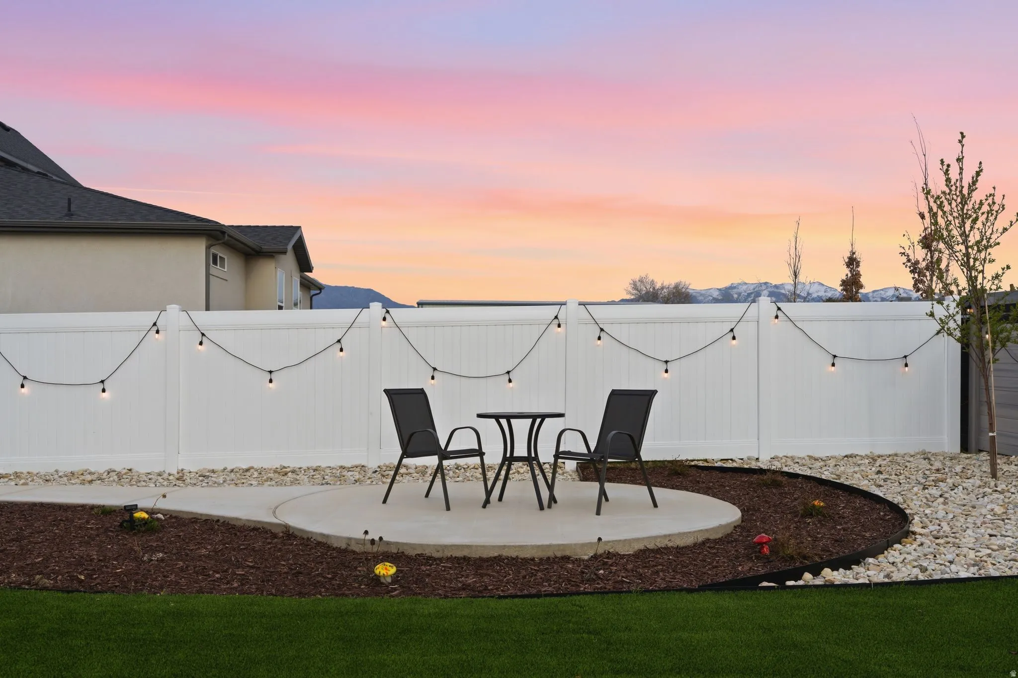 Yard at dusk with a fenced backyard and a patio