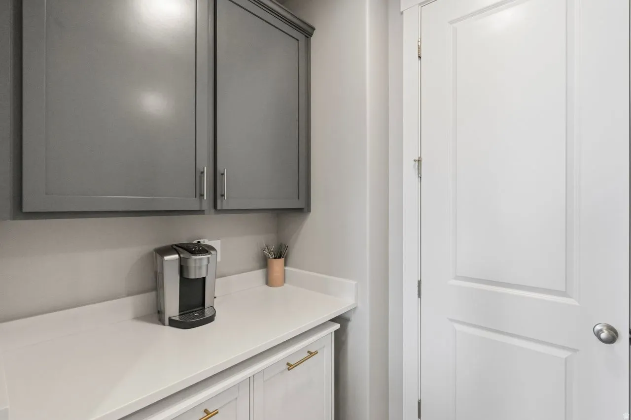 Bar featuring light countertops and gray cabinetry