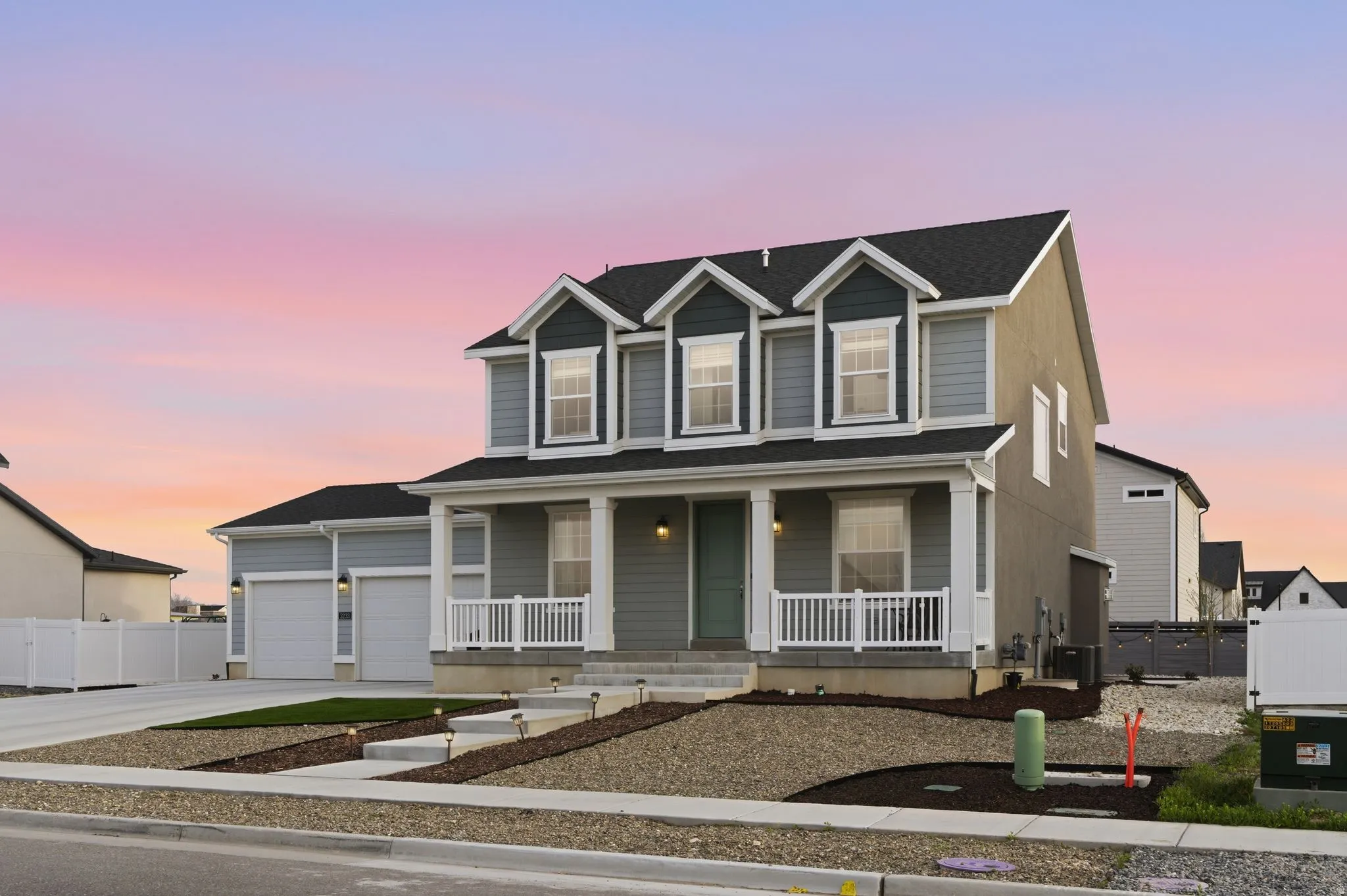View of front of house featuring covered porch, driveway, and a garage