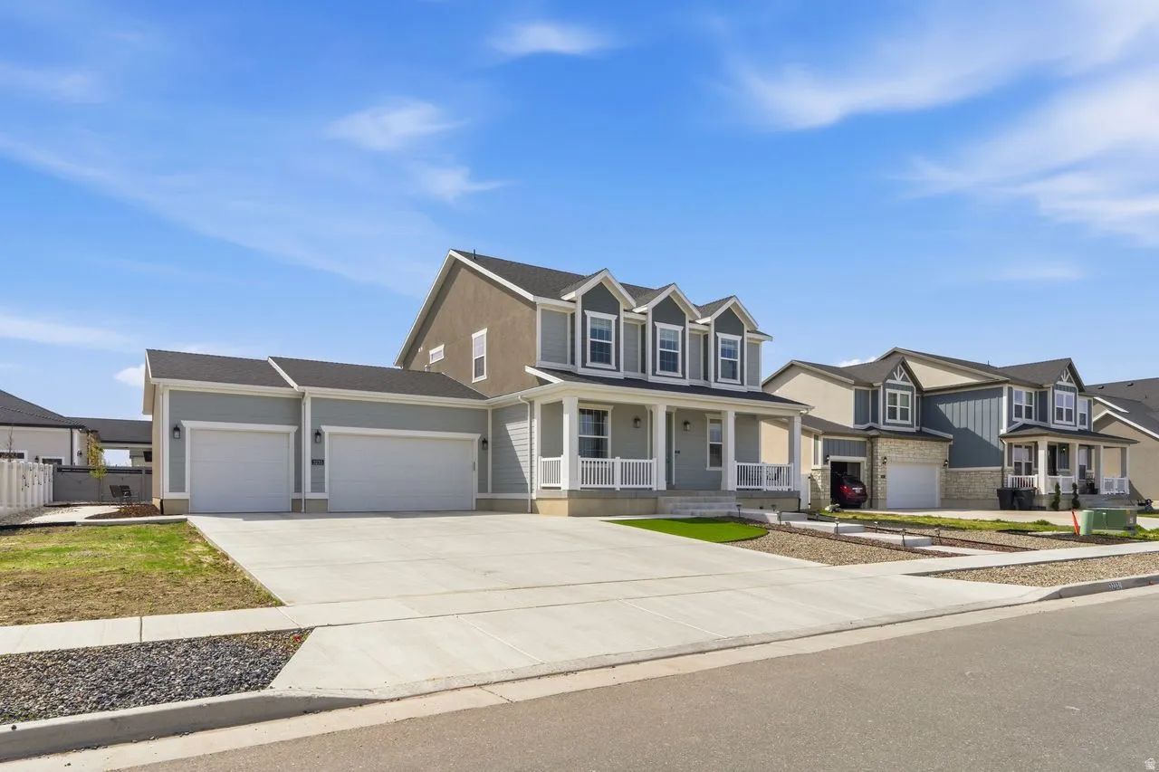 View of front of home featuring a porch, an attached garage, concrete driveway, and a residential view