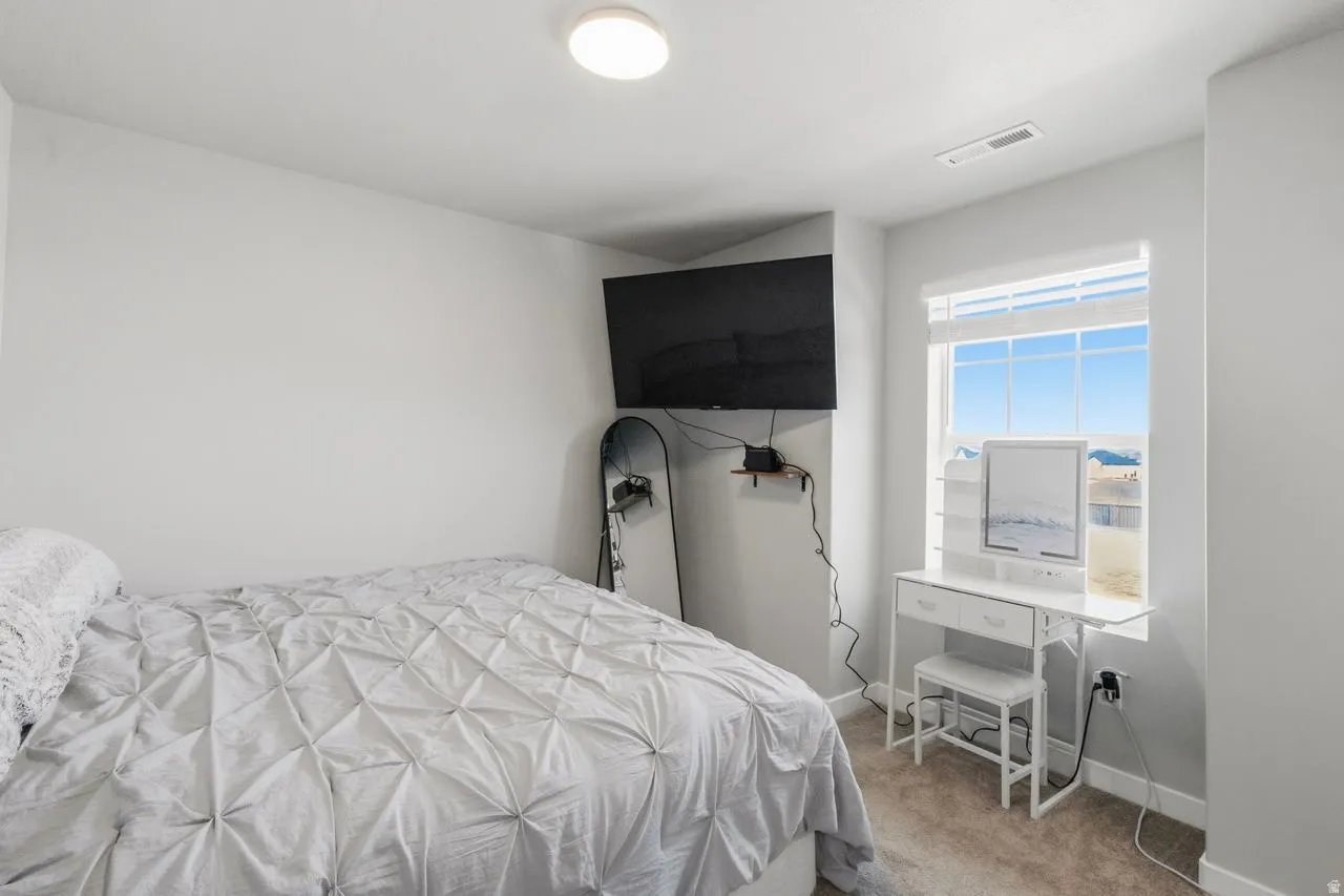 Bedroom featuring light colored carpet and baseboards