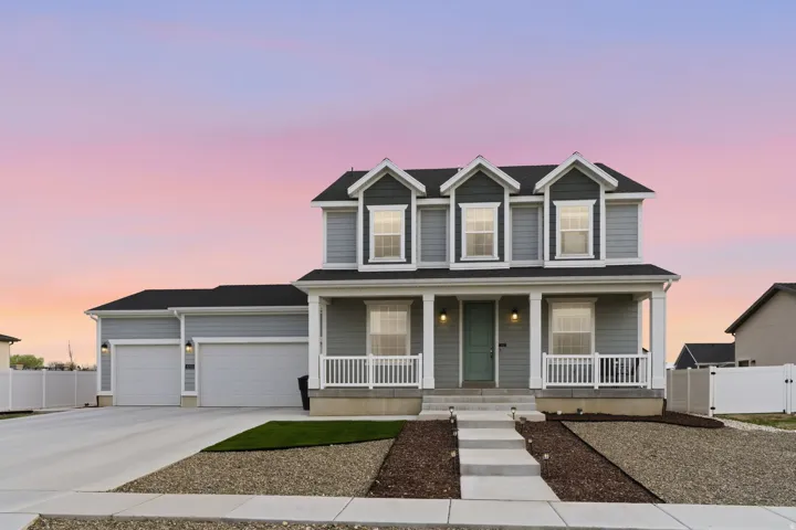 Traditional-style home with covered porch, a garage, concrete driveway, and a gate