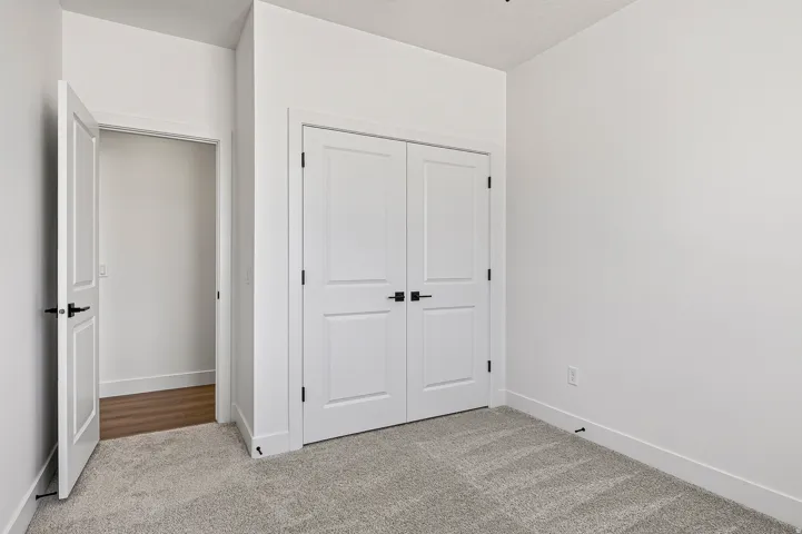Bedroom featuring light gray carpeting and white walls