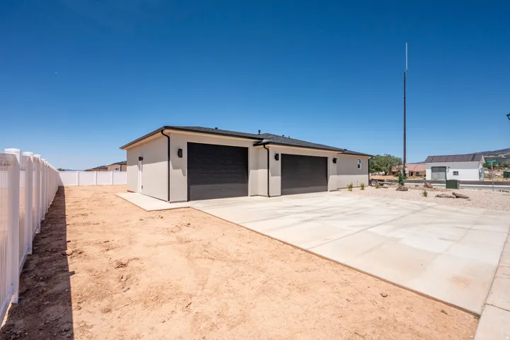 Contemporary exterior with a two-car garage featuring black doors and exterior lighting