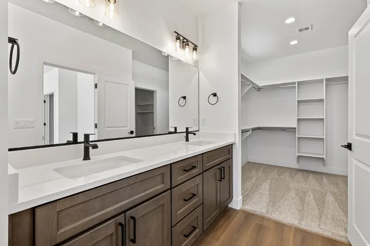 Dual sink vanity with quartz-finish countertop and dark wood-finish cabinetry