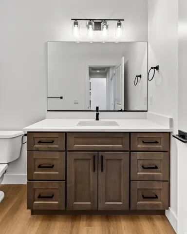 Vanity featuring a white countertop, undermount sink, and matte black faucet