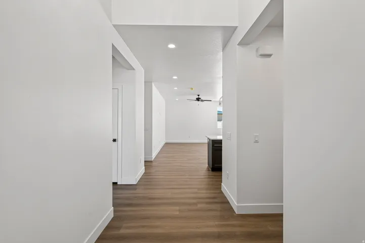 Open-concept interior featuring wood-finish flooring, recessed lighting, and a modern ceiling fan