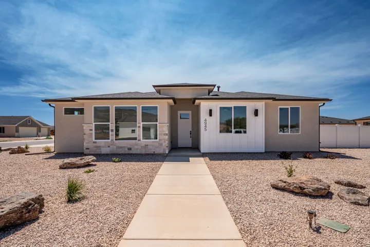Contemporary single-story residence featuring a stucco exterior with stone accents and vertical white siding
