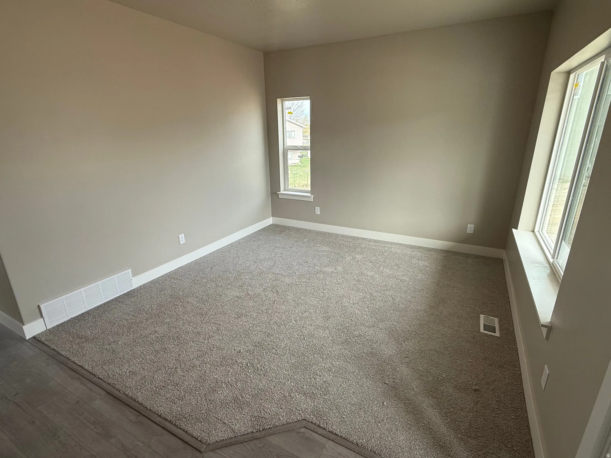 Carpeted empty room with baseboards