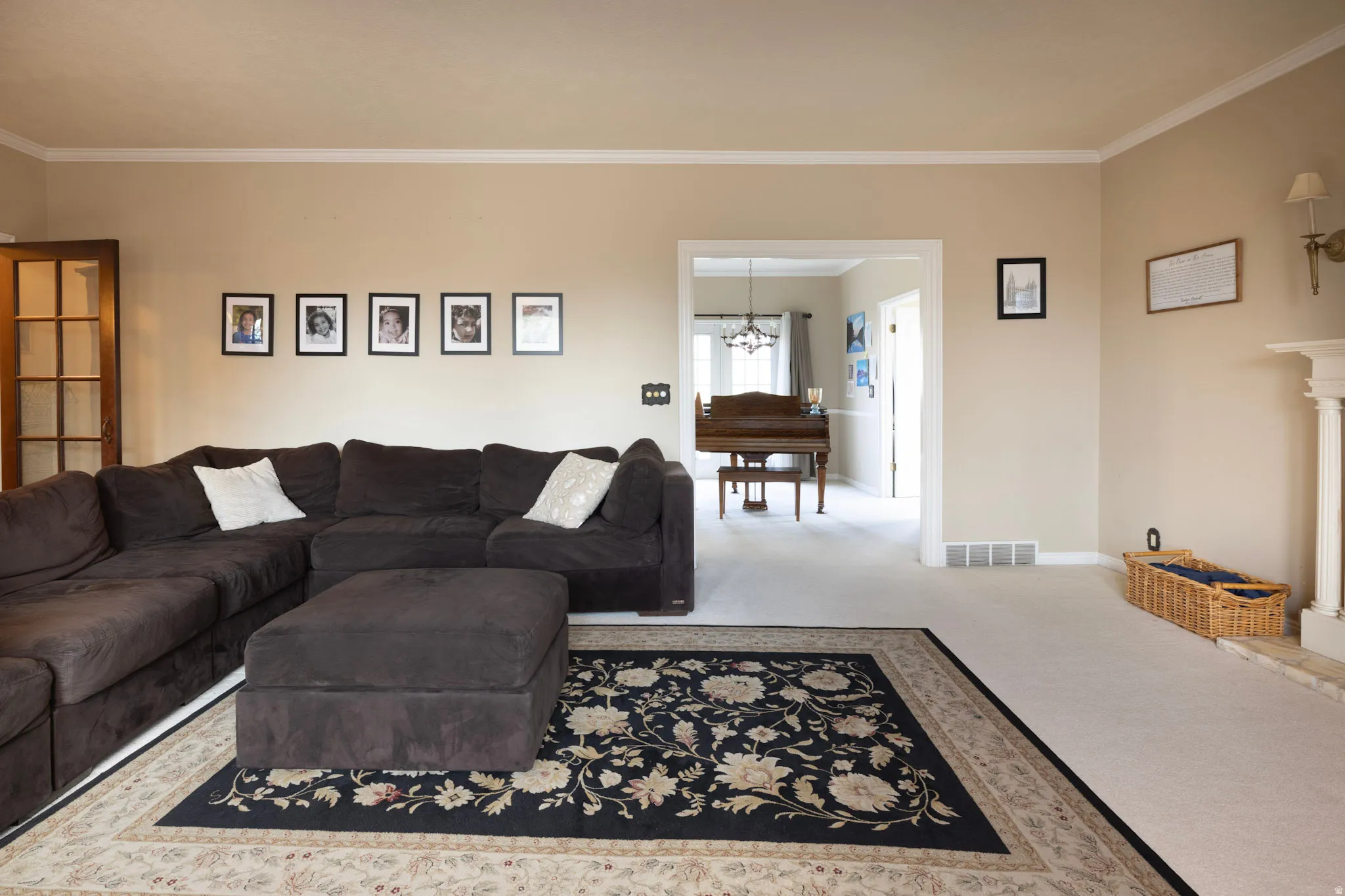 Living area with carpet flooring, crown molding, and hanging lights