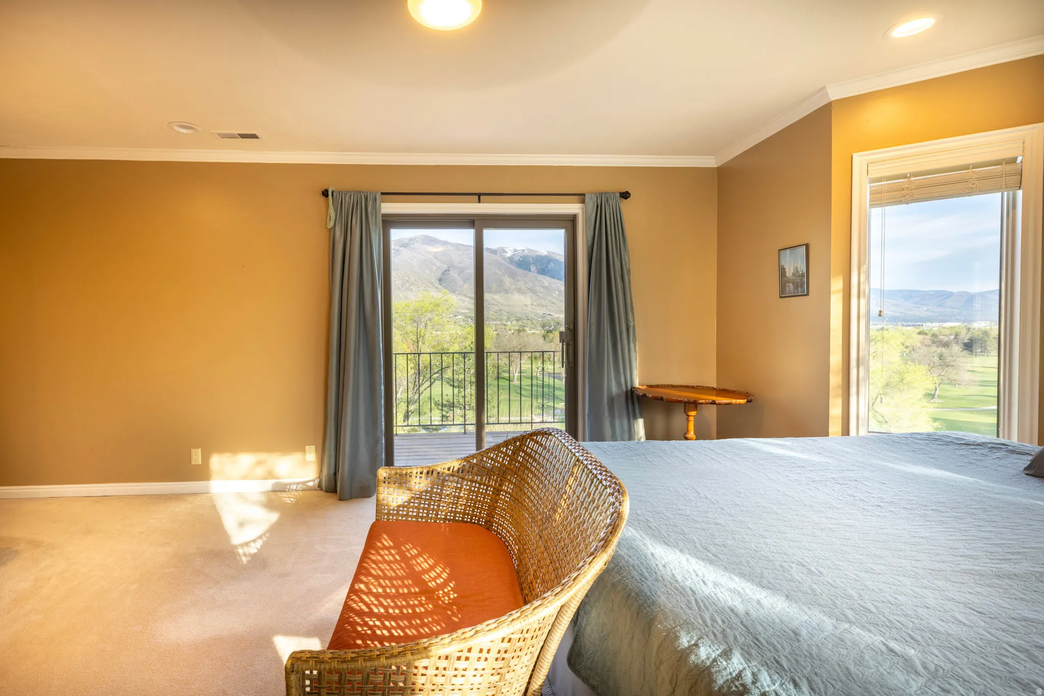 Bedroom with access to outside, a mountain view, ornamental molding, carpet floors, and a ceiling fan