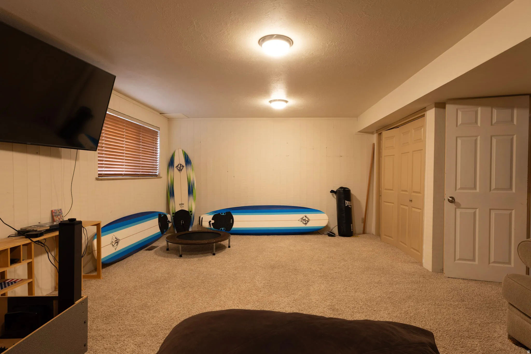 Exercise area featuring light carpet and a textured ceiling