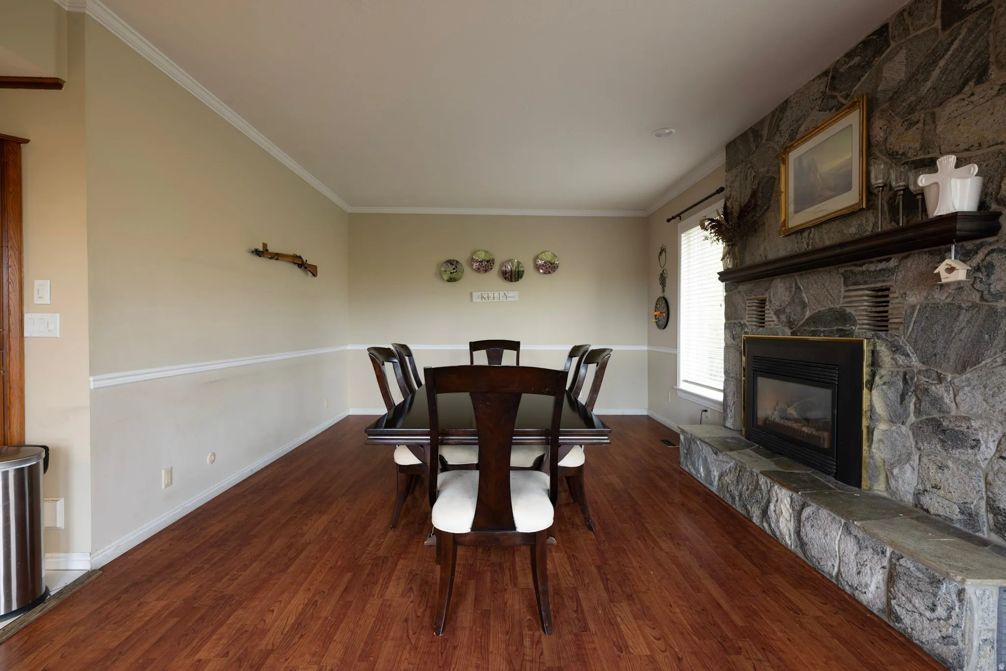 Dining space featuring a fireplace, ornamental molding, and dark wood-type flooring