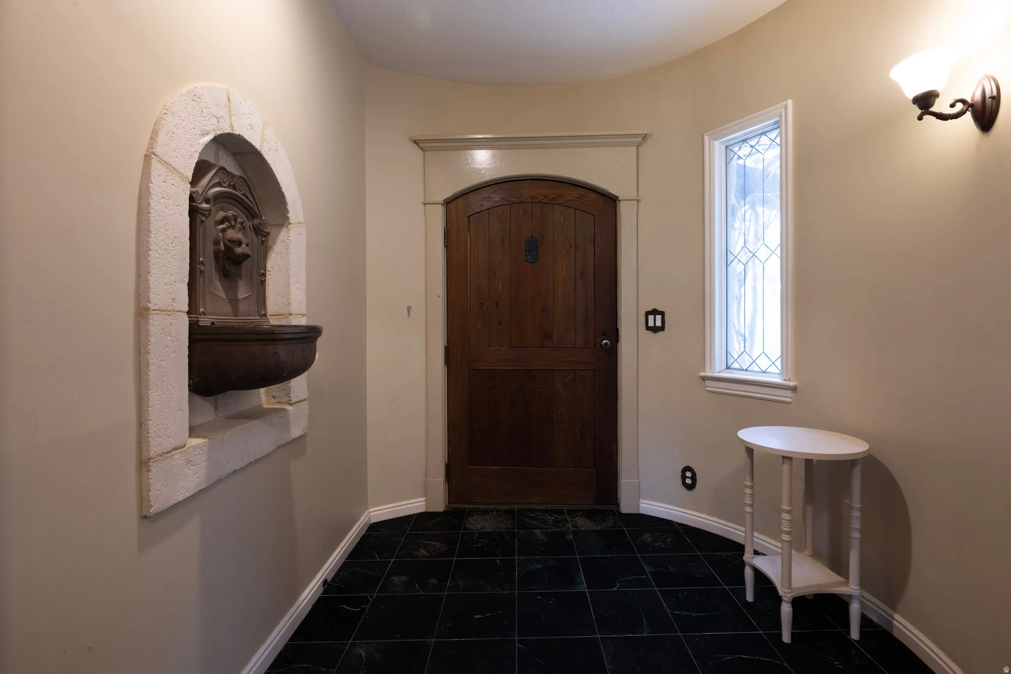 Foyer featuring dark tile patterned flooring and baseboards