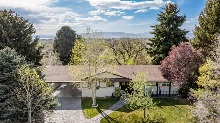 View of subject property with a mountain backdrop and a tree filled landscape