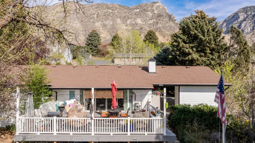 Rear view of house featuring a chimney, an outdoor living / dining area, and a deck with mountain view