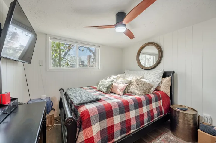 Bedroom with a ceiling fan, wood finished floors, and a textured ceiling