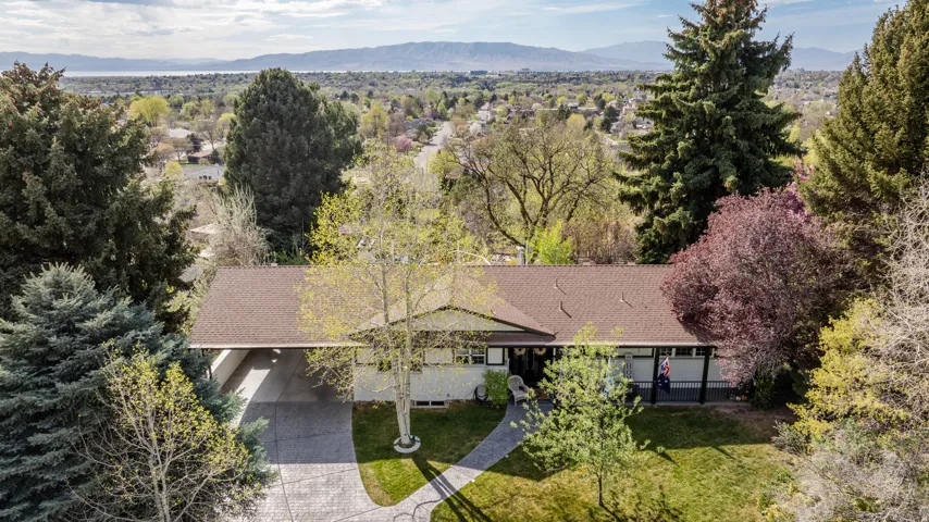 View from above of property featuring a mountainous background and a tree filled landscape