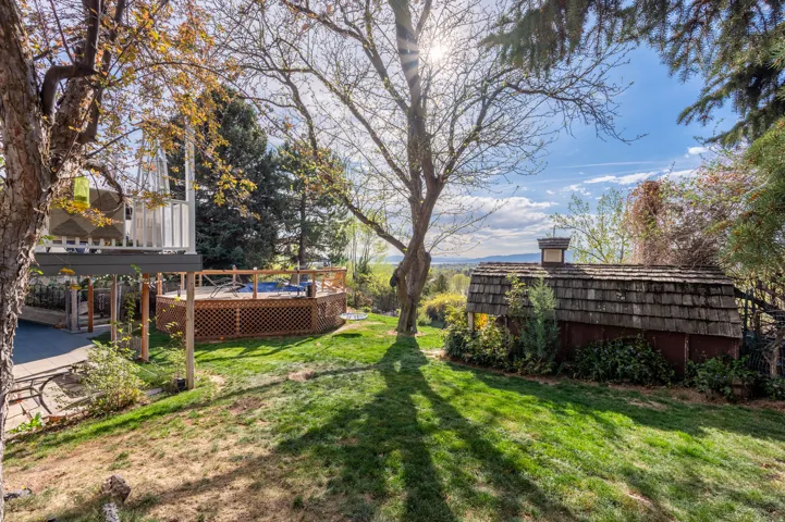 View of grassy yard featuring a deck