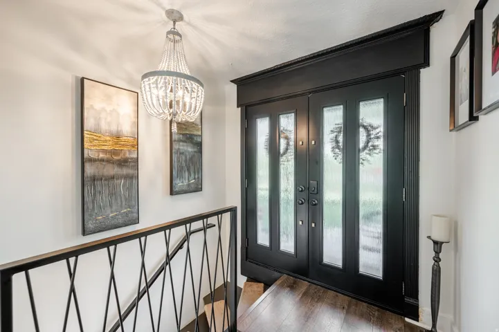 Foyer entrance featuring dark wood-style flooring and a chandelier