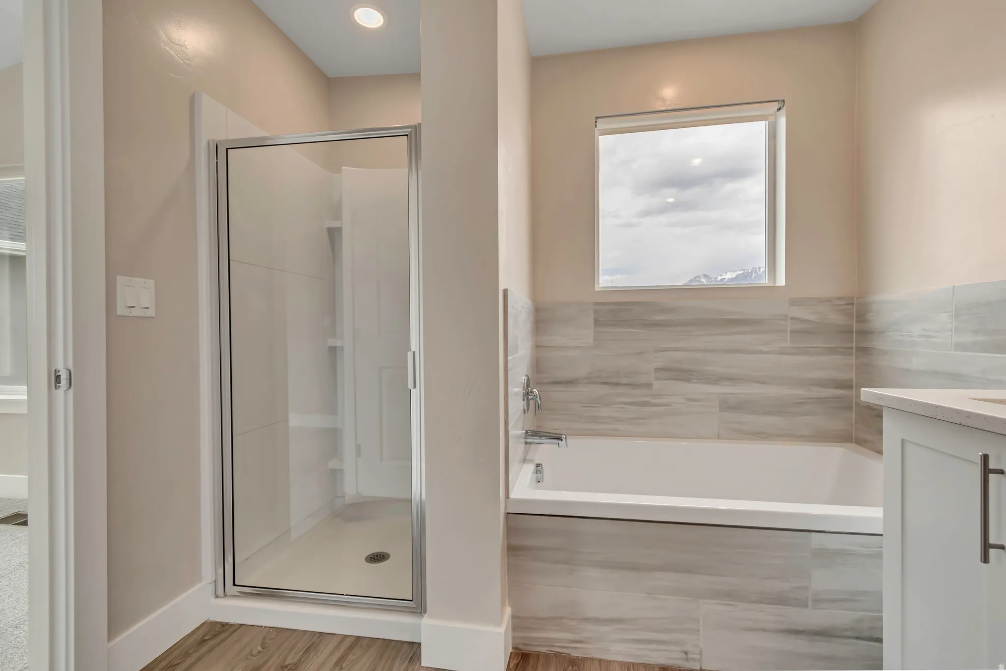 Bathroom of primary bedroom with separate tub and shower combo.