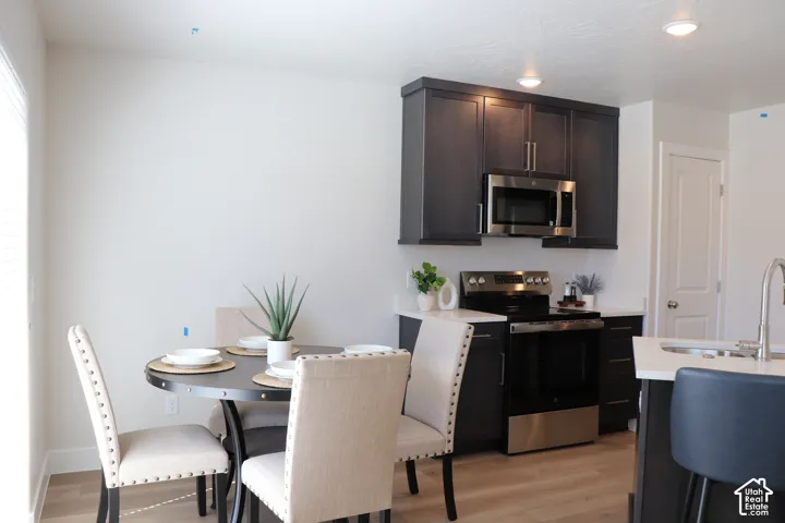 Modern kitchen featuring dark cabinetry, stainless steel appliances, and light countertops