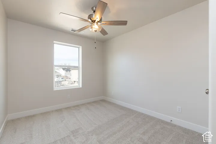 Unfurnished room with light carpet and a ceiling fan