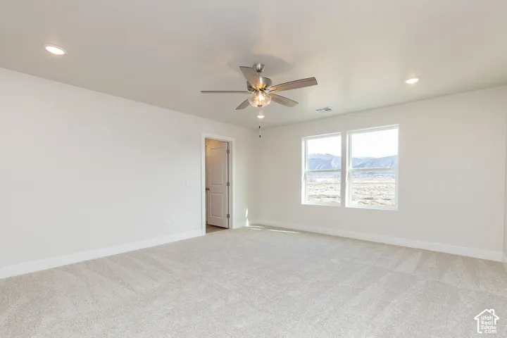 Spare room featuring light carpet, ceiling fan, a mountain view, and recessed lighting