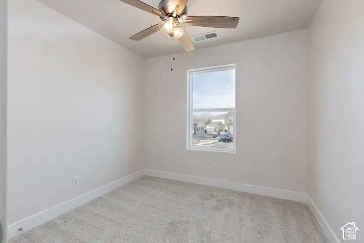 Unfurnished room featuring light carpet and ceiling fan