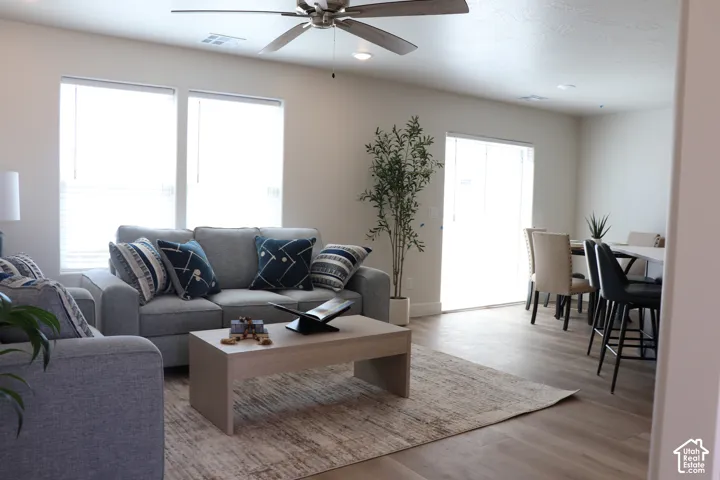 Open-concept living area featuring wood-finish flooring, recessed lighting, and a ceiling fan