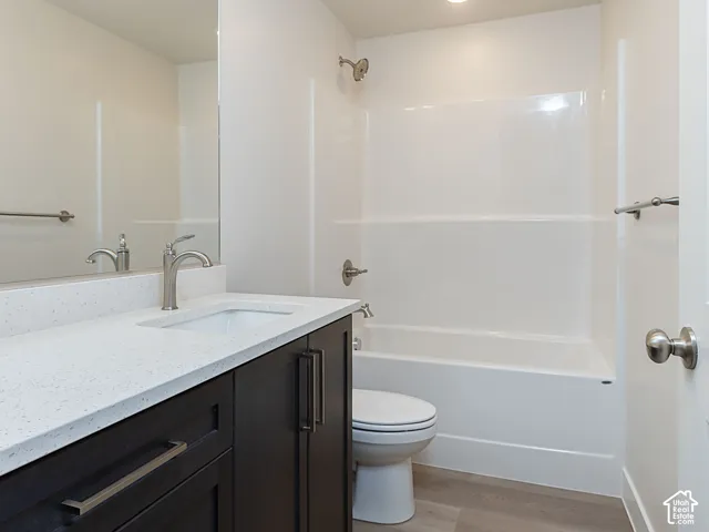 Bathroom featuring vanity, light wood-style floors, shower / tub combination, and recessed lighting
