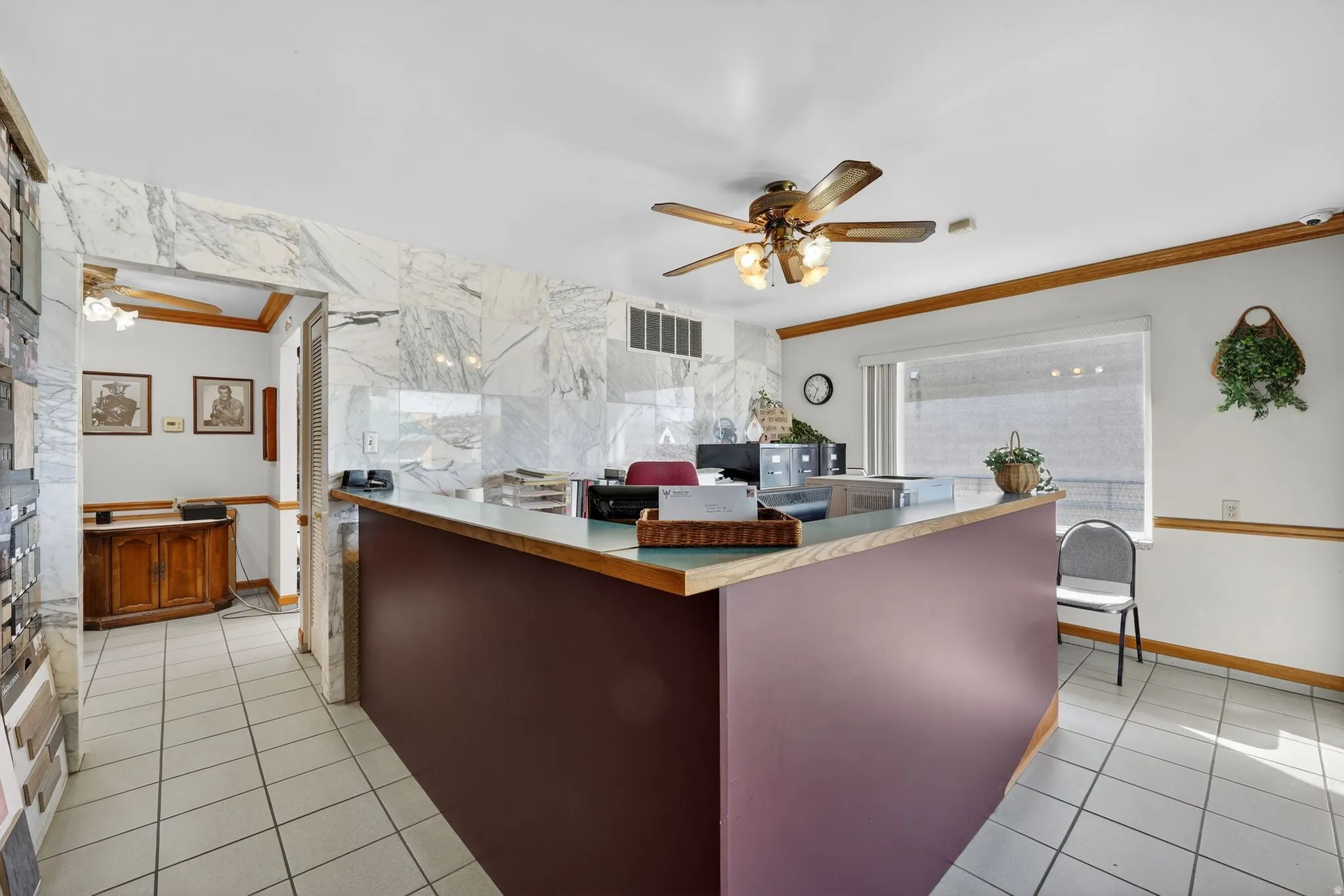 Office area with a ceiling fan, ornamental molding, and tile walls
