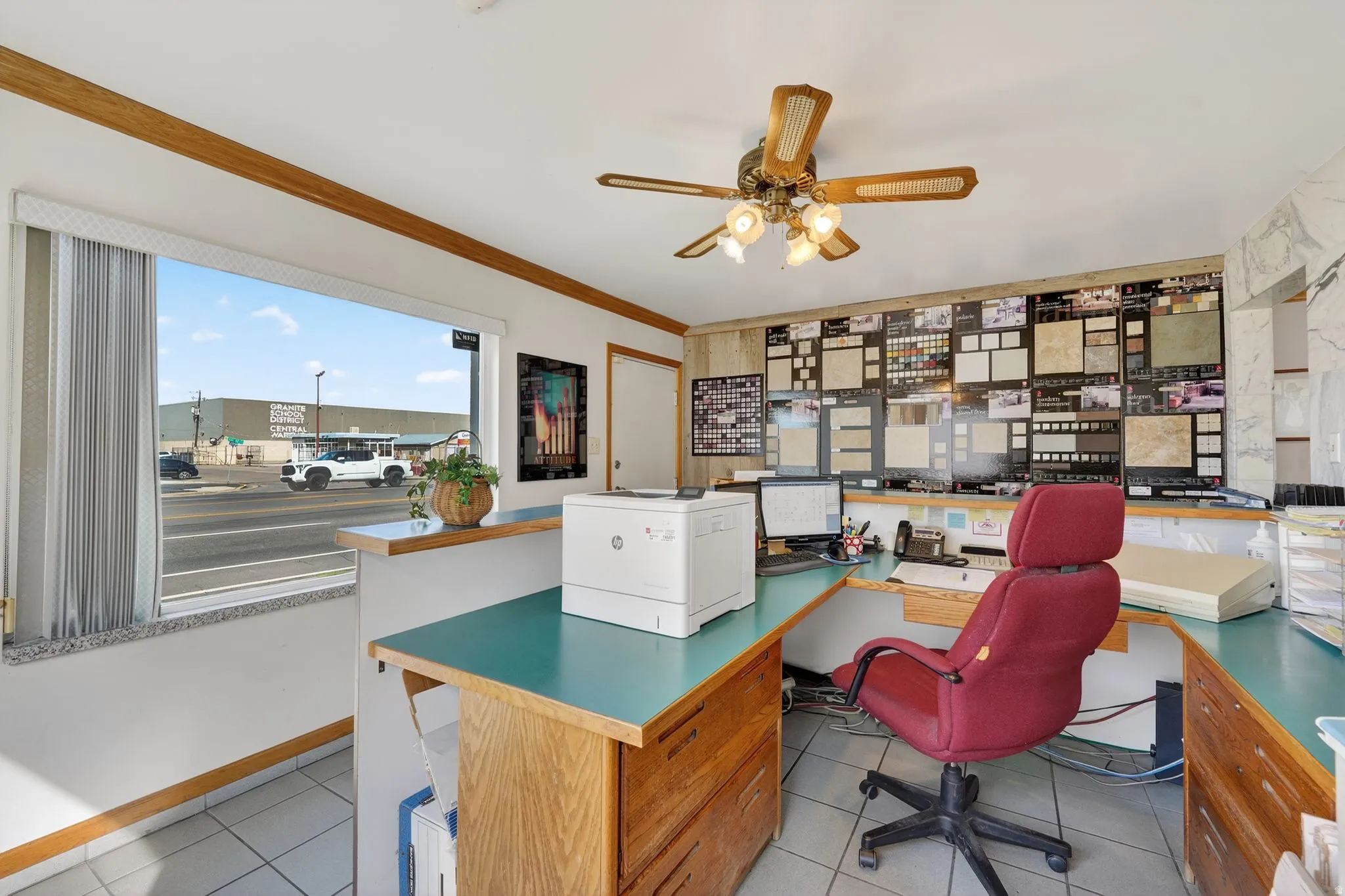 Office area featuring built in desk, ornamental molding, and ceiling fan