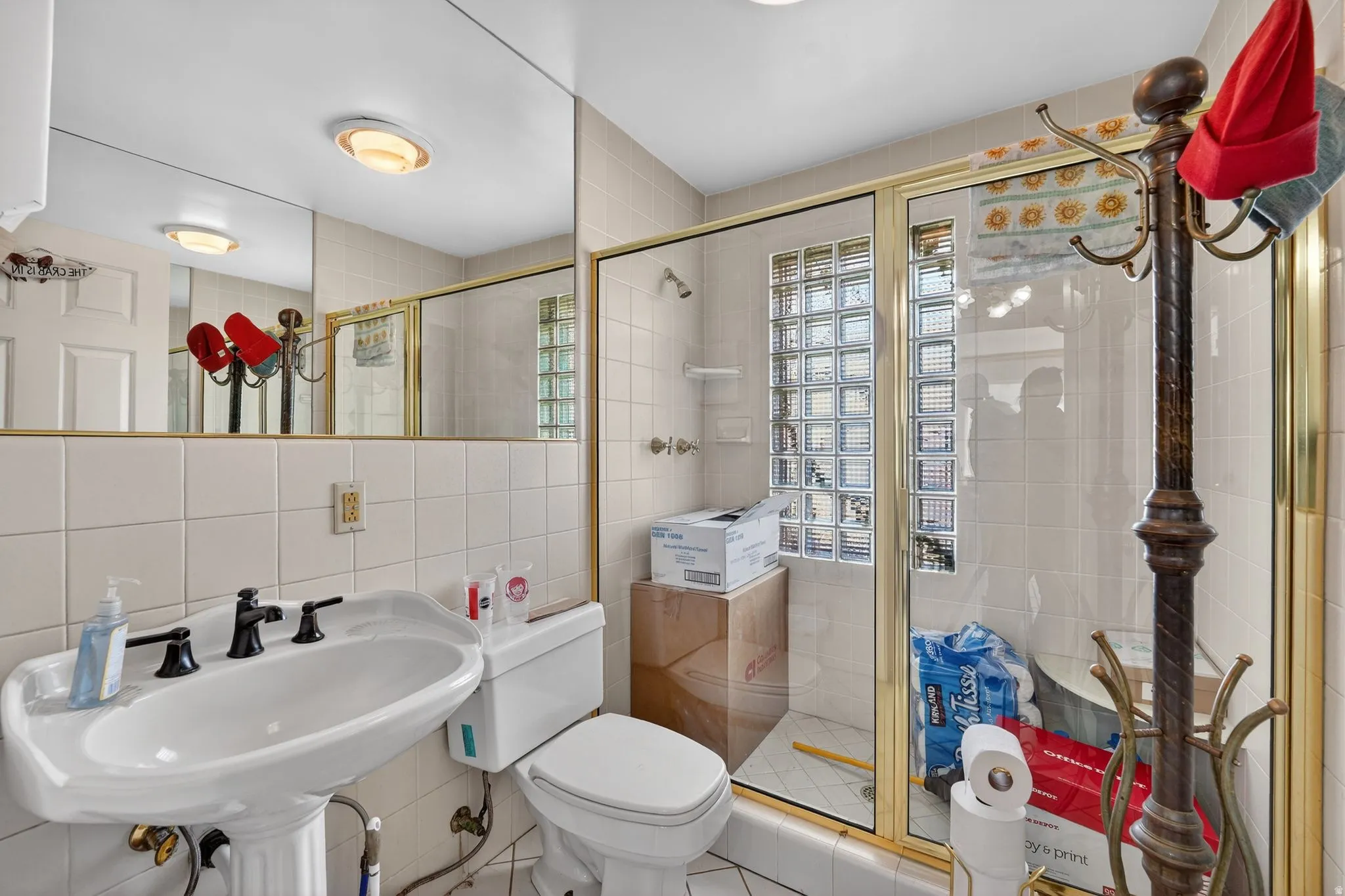 Bathroom featuring tile walls, a stall shower, and tasteful backsplash