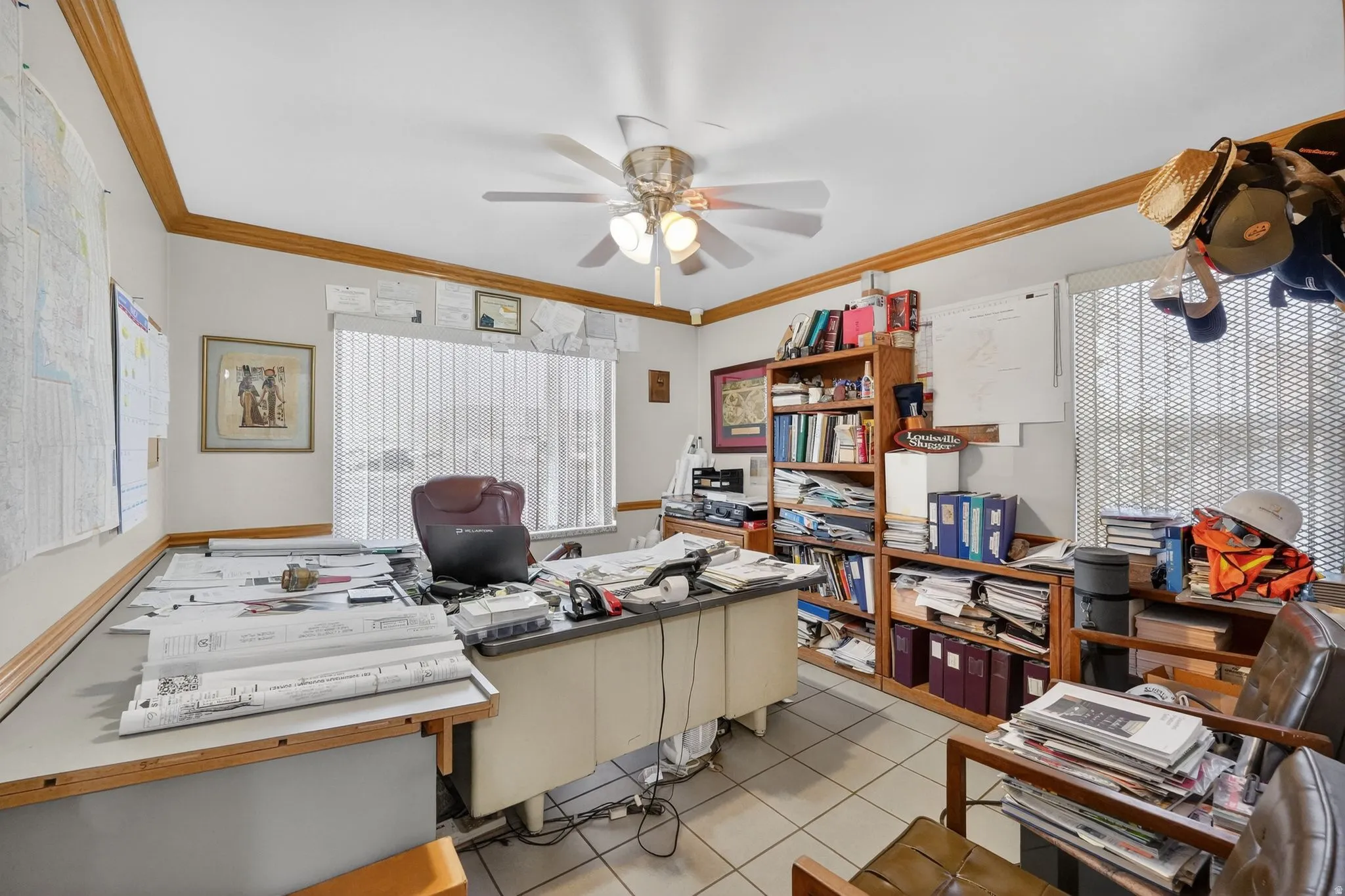 Home office featuring light tile patterned floors, a ceiling fan, and ornamental molding