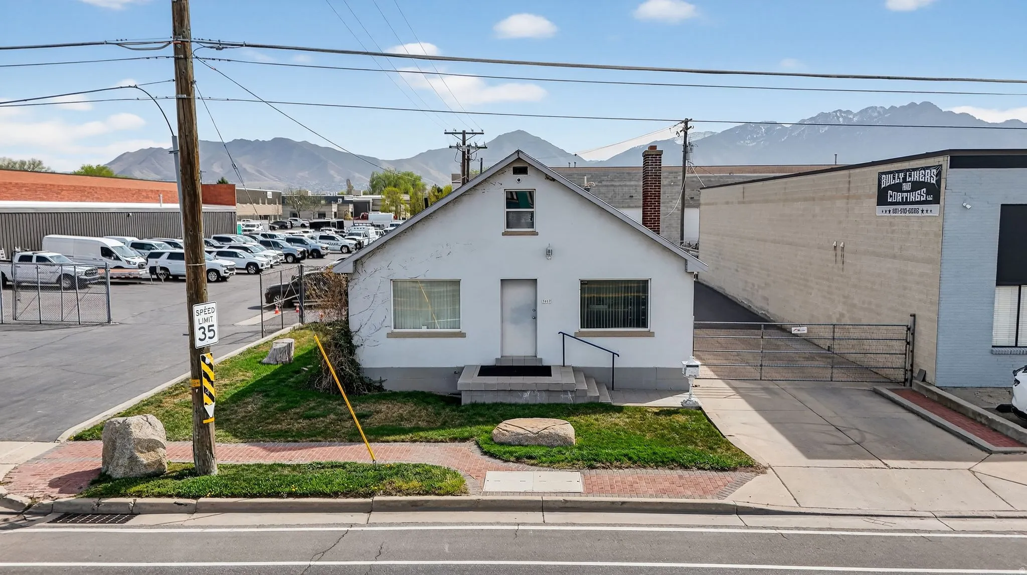 View of front of home featuring a mountain view, stucco siding, a chimney, and uncovered parking