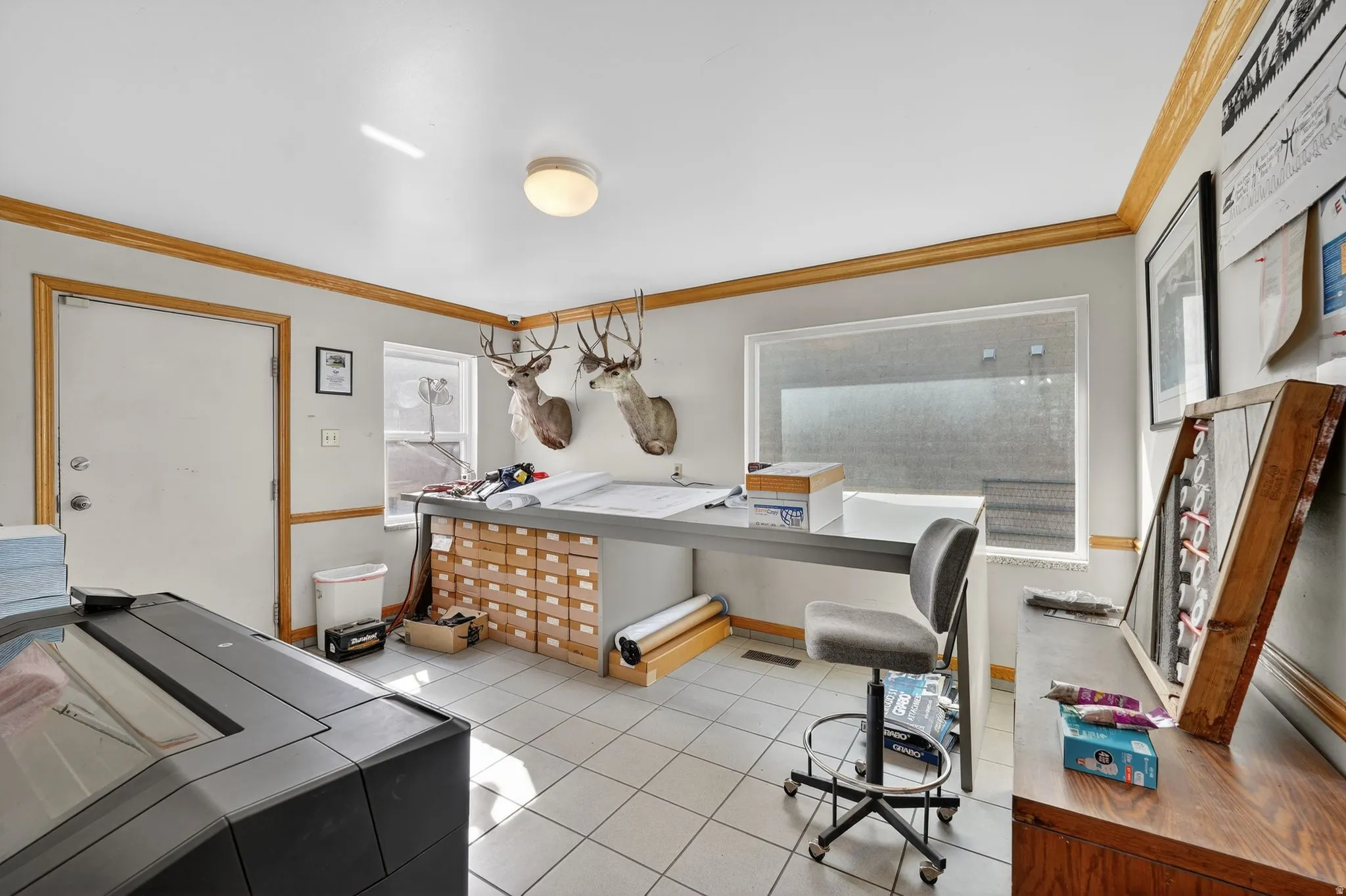 Home office with crown molding and light tile patterned floors