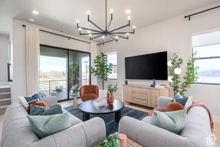 Living area featuring a modern black multi-arm chandelier, large-format sliding glass doors, recessed lighting, and expansive windows