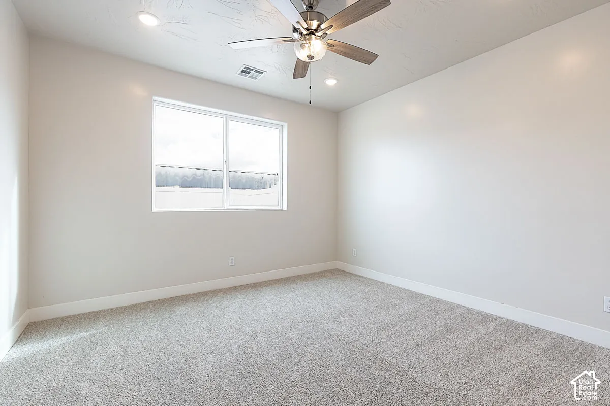 Unfurnished room with light colored carpet, a ceiling fan, and recessed lighting