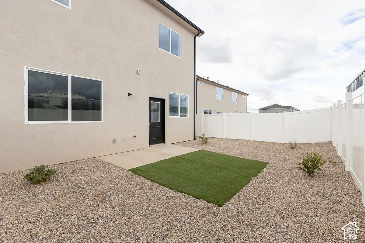 Rear view of property featuring a fenced backyard, stucco siding, and a patio area